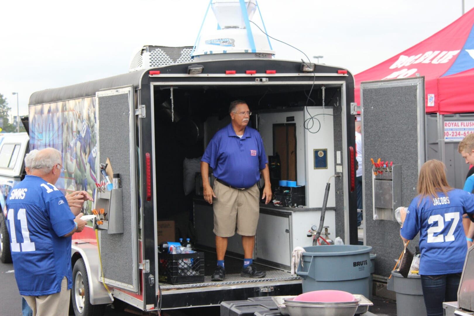 A man standing in the doorway of an enclosed trailer.