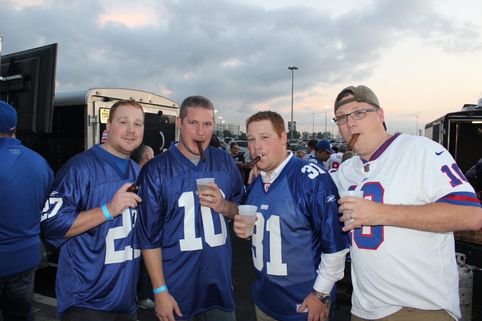 A group of men in football jerseys drinking beer.