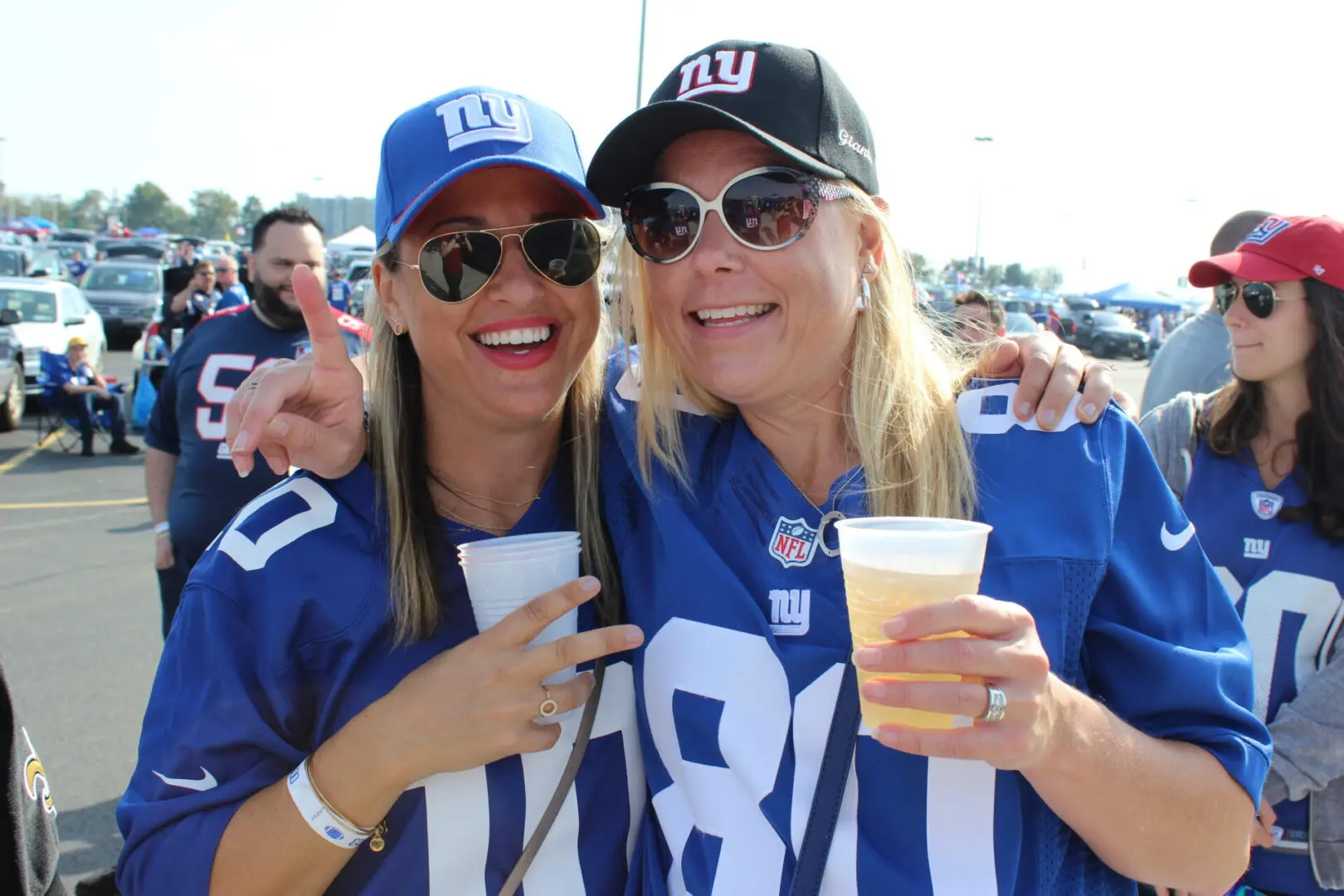 Two women are holding cups and posing for a picture.
